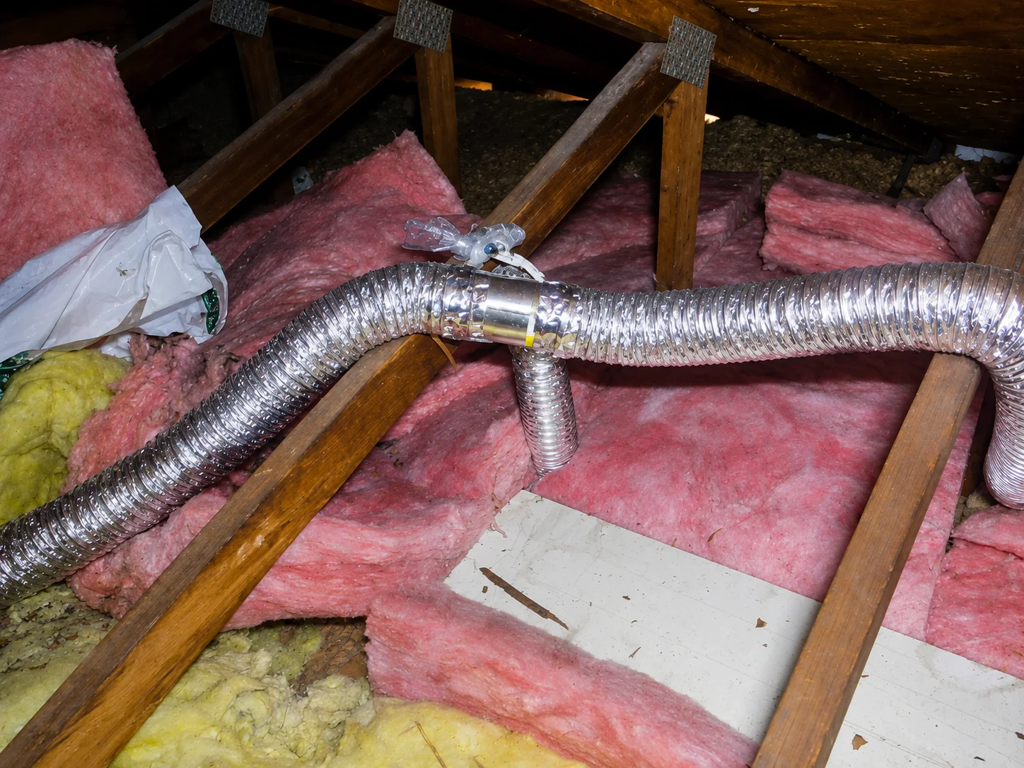 Bathroom exhaust ducts joined through a Y-connector in an attic