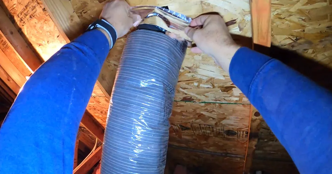Foil tape being applied to seal a bathroom exhaust duct connection