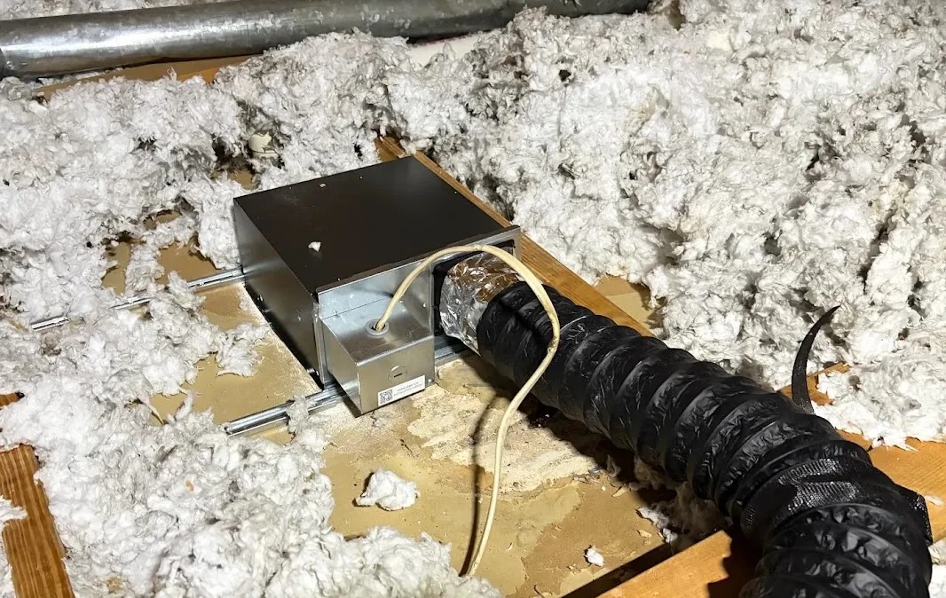Completed bathroom fan duct connection secured and sealed at the fan housing